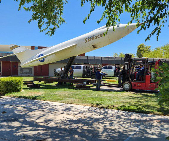 Workers prepare to move the historic Douglas D-558-II Skyrocket into storage to protect it during ongoing campus construction at Antelope Valley College in Lancaster, Calif., on July 19, 2024. The plane was donated in 1963 and dedicated to the “youth of Antelope Valley,” according to the AVC website. One of only three Skyrockets built, Albert Scott Crossfield piloted a sister ship, now in the Smithsonian Air and Space Museum, to twice the speed of sound in 1953. 
Photo by Lisa Kinison 