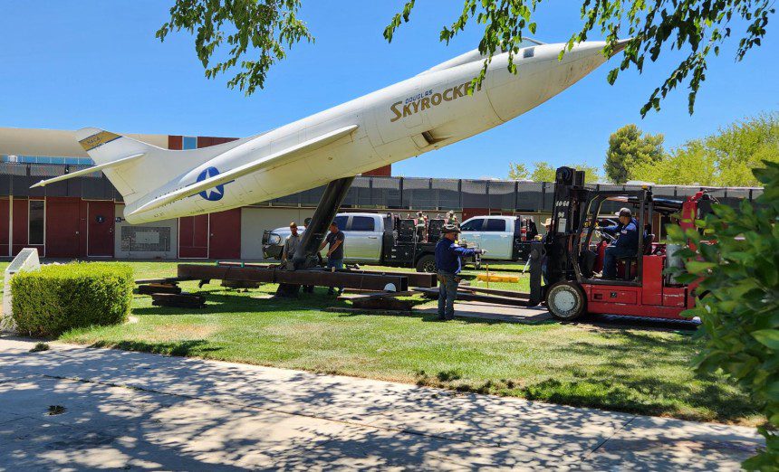 Workers prepare to move the historic Douglas D-558-II Skyrocket into storage to protect it during ongoing campus construction at Antelope Valley College in Lancaster, Calif., on July 19, 2024. The plane was donated in 1963 and dedicated to the “youth of Antelope Valley,” according to the AVC website. One of only three Skyrockets built, Albert Scott Crossfield piloted a sister ship, now in the Smithsonian Air and Space Museum, to twice the speed of sound in 1953. 
Photo by Lisa Kinison 