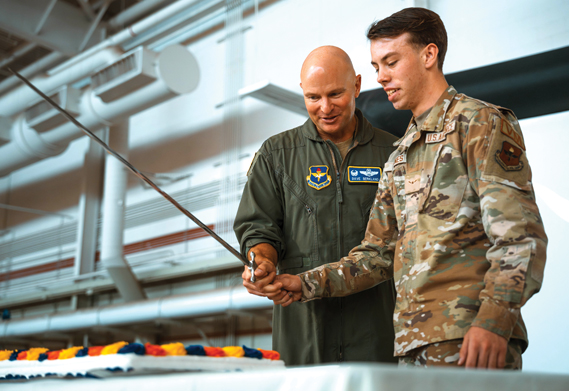 U.S. Air Force Col. David Berkland (left), 56th Fighter Wing commander, cuts the cake with Airman Preston Jones, 56th Logistics Readiness Squadron vehicle maintenance apprentice, at the 77th Air Force Ball, Sept. 13, 2024, at Luke Air Force Base, Arizona. The evening featured an array of traditions and presentations, a video presentation on the history of Luke AFB was shown, followed by a group of enlistees taking the oath of enlistment and the traditional cake-cutting ceremony. (U.S. Air Force photos by Senior Airman Mason Hargrove)