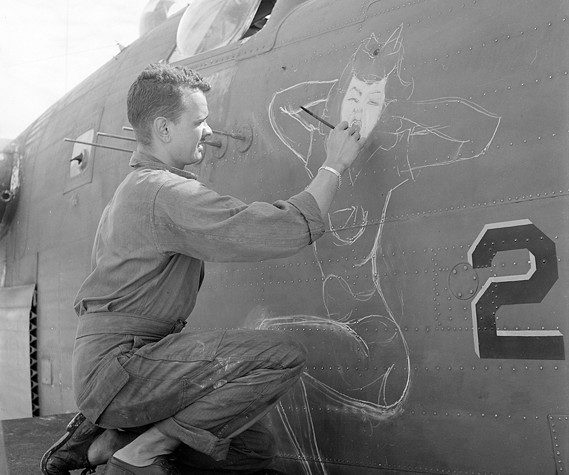 Sgt. J.S. Wilson paints a bomber based at Eniwetok Atoll, in the Marshall Islands. in June 1944. (National Archives photograph)