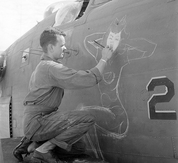 Sgt. J.S. Wilson paints a bomber based at Eniwetok Atoll, in the Marshall Islands. in June 1944. (National Archives photograph)