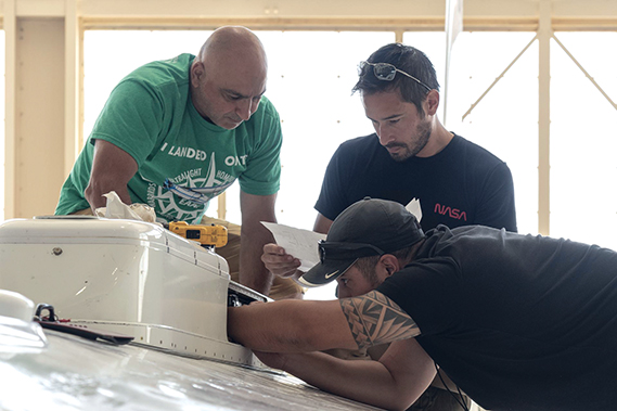 Sam Habbal (quality inspector), Darick Alvarez (aircraft mechanic), and Juan Alvarez (crew chief) work on the network “canoe” on top of the ER-2 aircraft, which provides network communication with the pilot onboard. Experts like these sustain a high standard of safety while outfitting instruments onboard science aircraft like the ER-2 and science missions like the Plankton, Aerosol, Cloud, ocean Ecosystem Postlaunch Airborne eXperiment (PACE-PAX) mission. The ER-2 is based out of NASA’s Armstrong Flight Research Center at Edwards, Calif. (NASA photograph by Genero Vavuris)