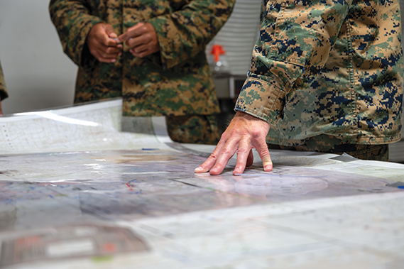 U.S. Marines assigned to the 1st Marine Regiment, 1st Marine Division, review operation plans with U.S. Airmen during Marine Air-Ground Task Force Warfighting Exercise (MWX) at Marine Corps Air-Ground Combat Center, Twentynine Palms, California, Aug. 14, 2024. MWX is a week-long culminating event for a six-week service-level training exercise that assesses readiness by simulating threat from rival forces. (U.S. Air Force photo by Airman 1st Class Brianna Vetro).