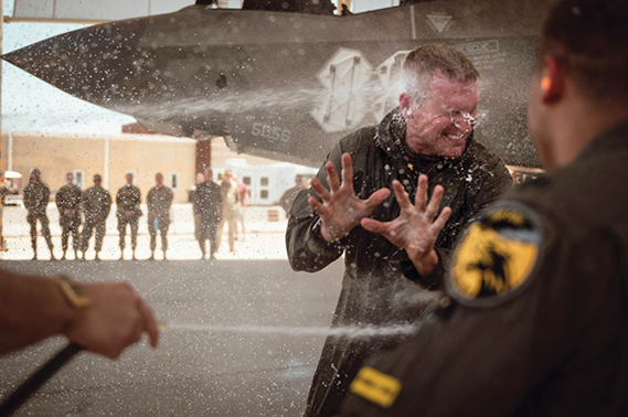 U.S. Air Force Brig. Gen. Jason Rueschhoff, 56th Fighter Wing commander, is sprayed with water after his finial flight, June 14, 2024, at Luke Air Force Base, Arizona. The final flight, commonly known as a fini flight, is a tradition for pilots and some aircrew members who are retiring or moving to another base. Part of the tradition is getting hosed with water by fellow Airmen as soon as they step out of the aircraft after the flight. (U.S. Air Force Photo by Senior Airman Katelynn Jackson)